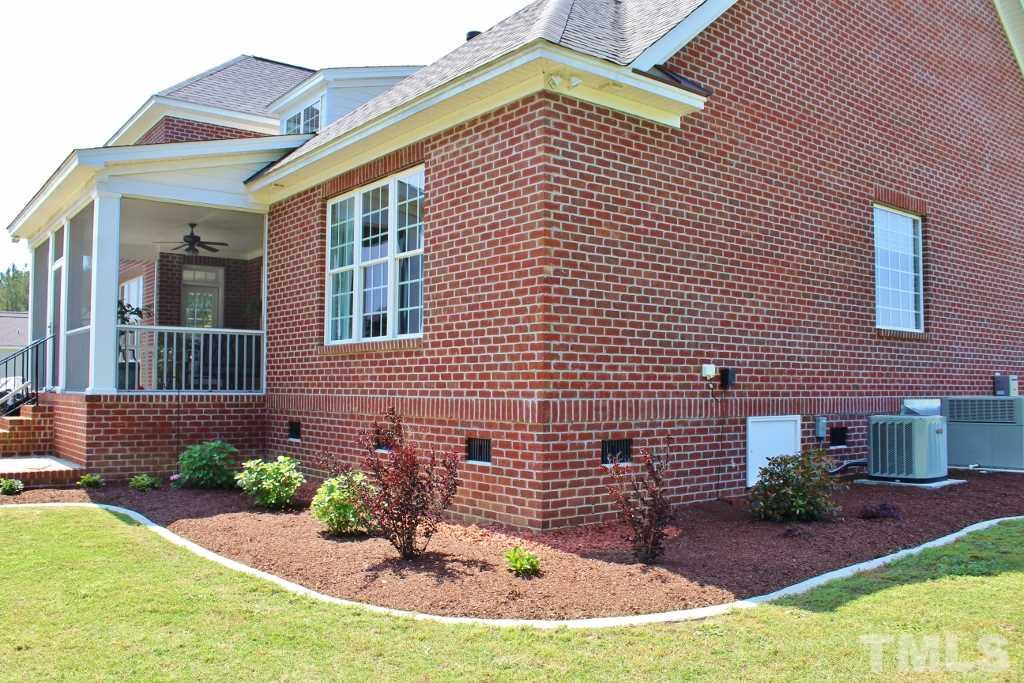 5820 Farmstead Road Bailey, NC 27807 - Photo 8 of 25 a view of a brick house with plants and many windows