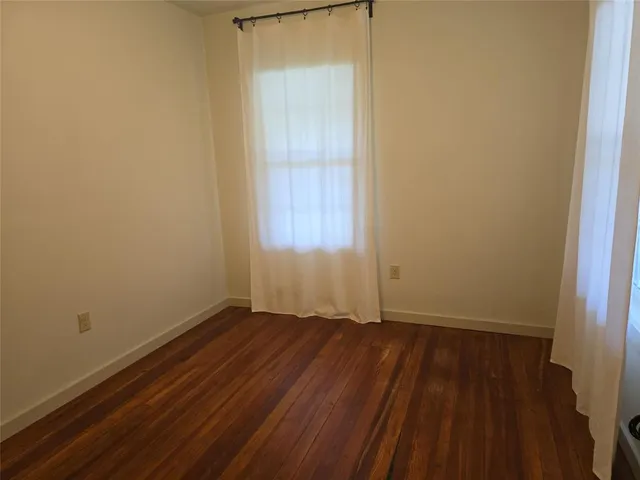 a view of a room with wooden floor and a small space