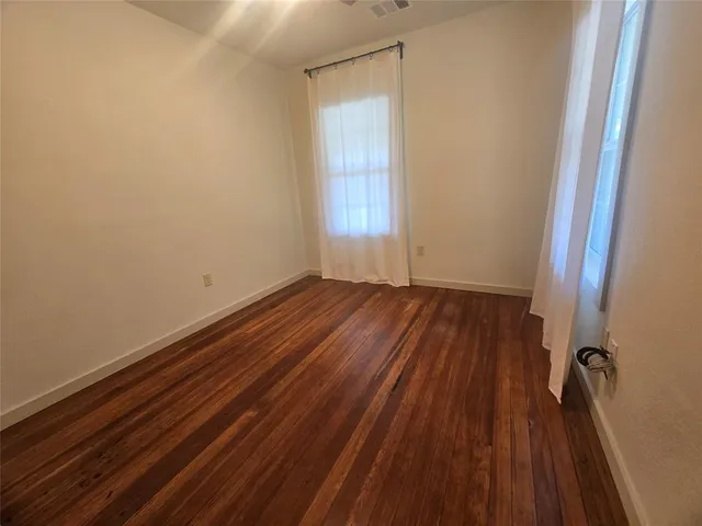 a view of a room with wooden floor and wooden door