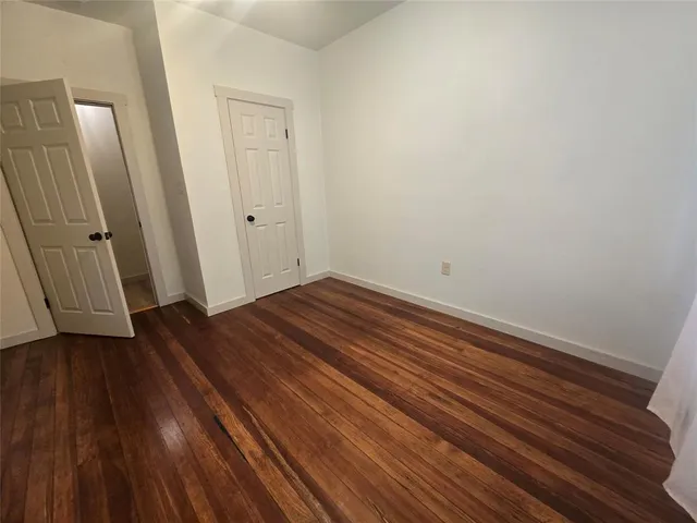 a view of a room with wooden floor and a sink