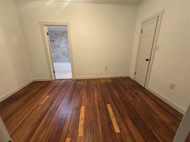 an empty room with wooden floor and entrance