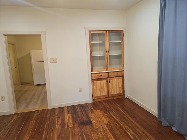 an empty room with wooden floor and closet