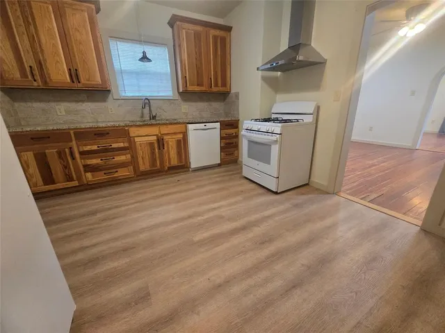 a kitchen with stainless steel appliances granite countertop a stove a sink and a microwave