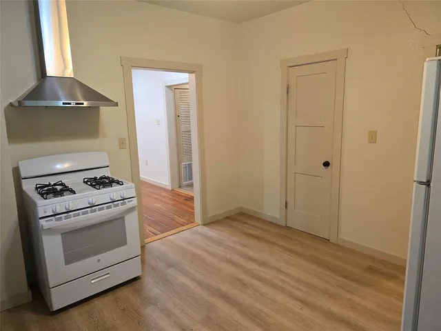 a kitchen with a stove and a wooden floor