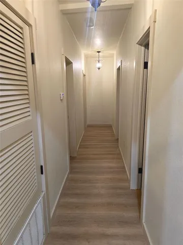 a view of a hallway with wooden floor and staircase