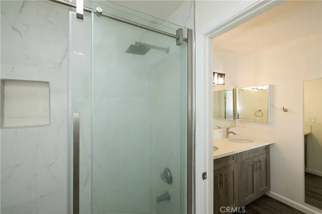 a bathroom with a shower sink and mirror