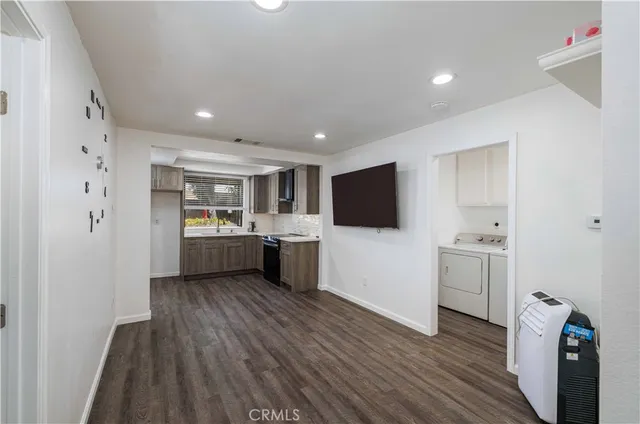 a view of a kitchen with wooden floor and electronic appliances