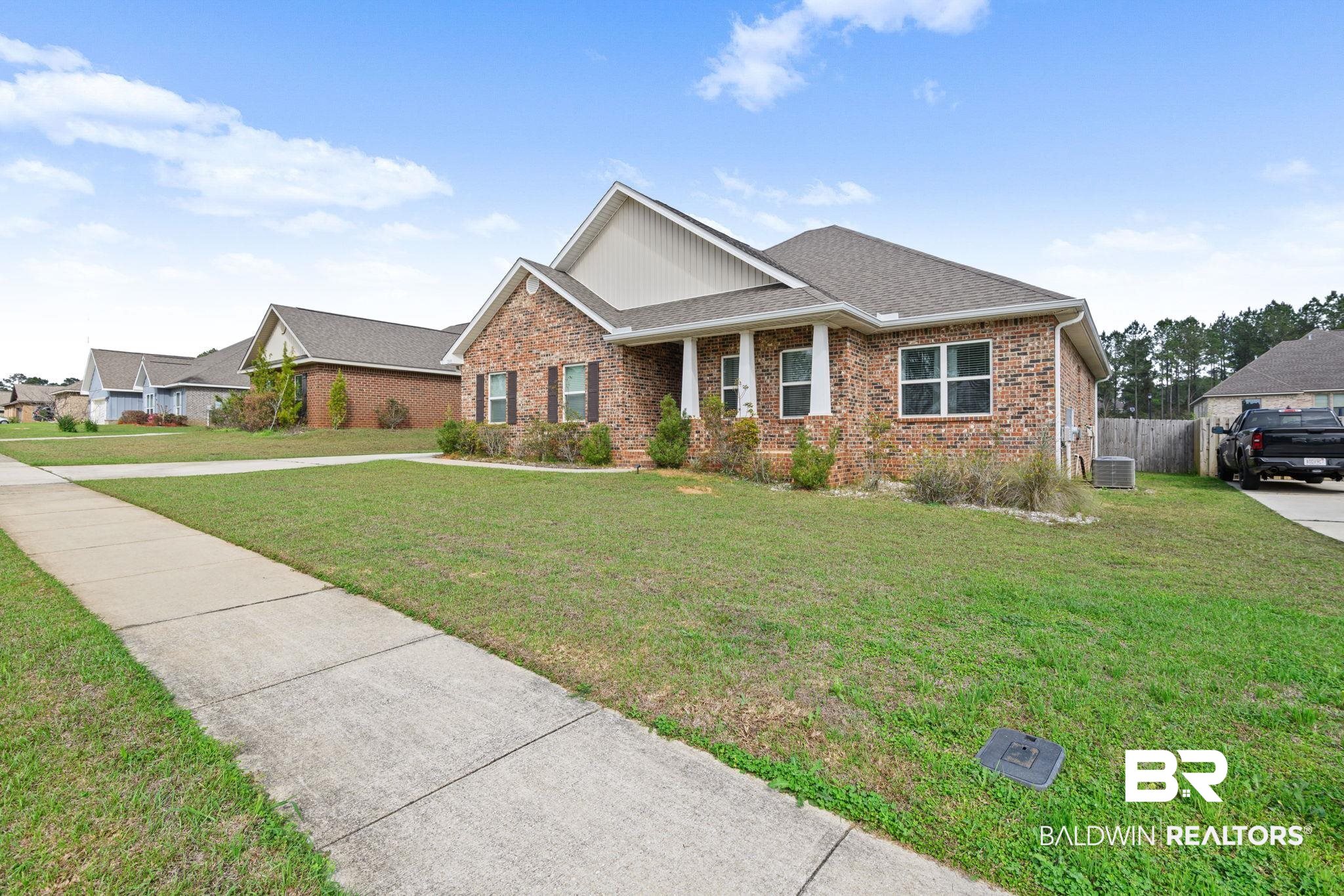 12693 Waxwing Avenue Daphne, AL 36527 - Photo 5 of 43 Craftsman-style home featuring roof with shingles, covered porch, and brick siding