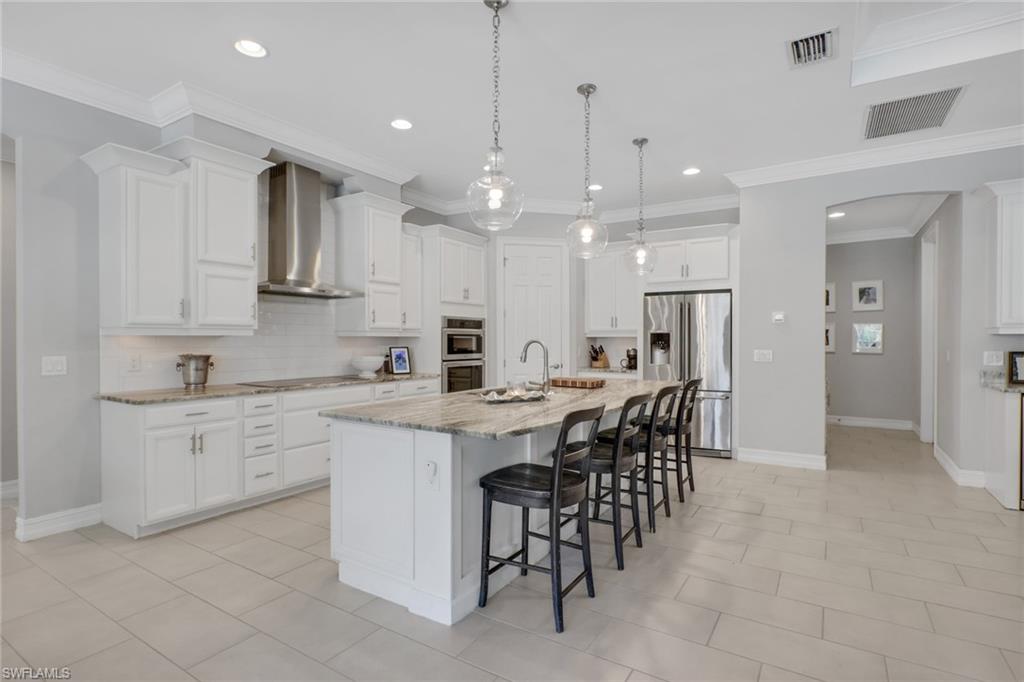 a kitchen with kitchen island a sink stove and white cabinets