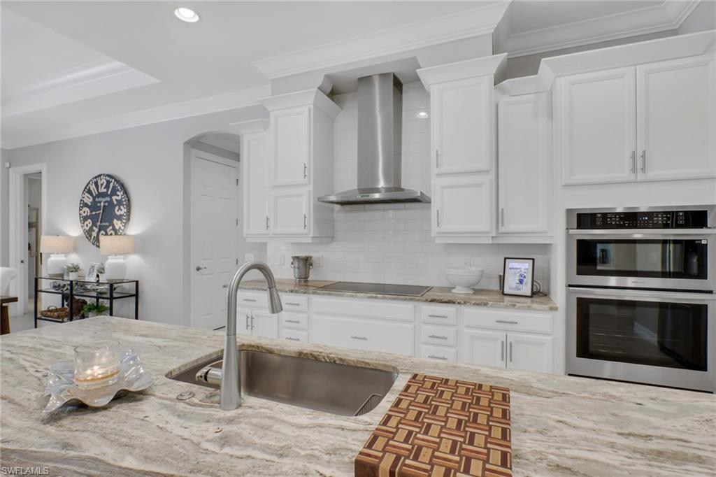 1511 Mockingbird Drive Naples, FL 34120 - Photo 12 of 44 a kitchen with granite countertop a stove a sink and a microwave