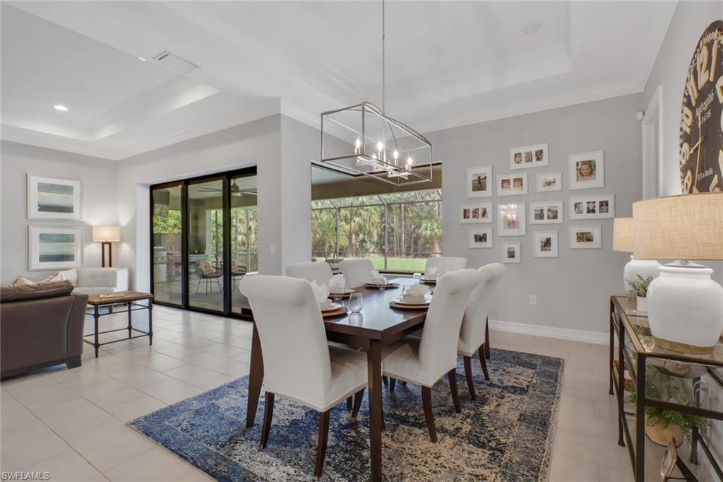 1511 Mockingbird Drive Naples, FL 34120 - Photo 15 of 44 a dining room with wooden floor a chandelier a glass table and chairs