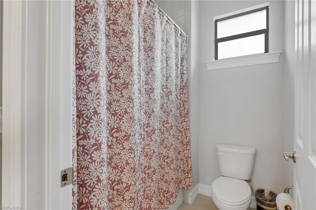 1511 Mockingbird Drive Naples, FL 34120 - Photo 26 of 44 a white toilet sitting next to a shower curtain
