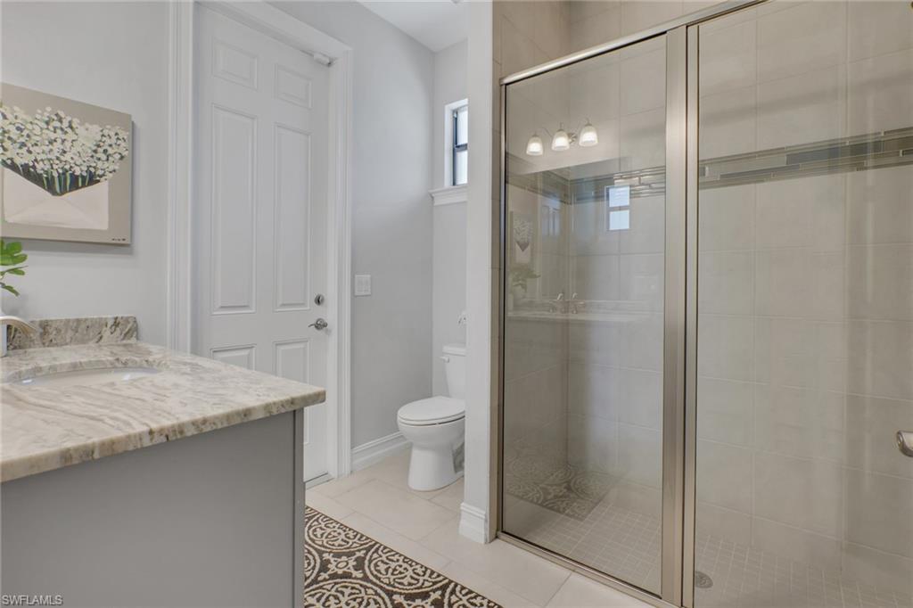 1511 Mockingbird Drive Naples, FL 34120 - Photo 30 of 44 a bathroom with a granite countertop sink toilet and shower
