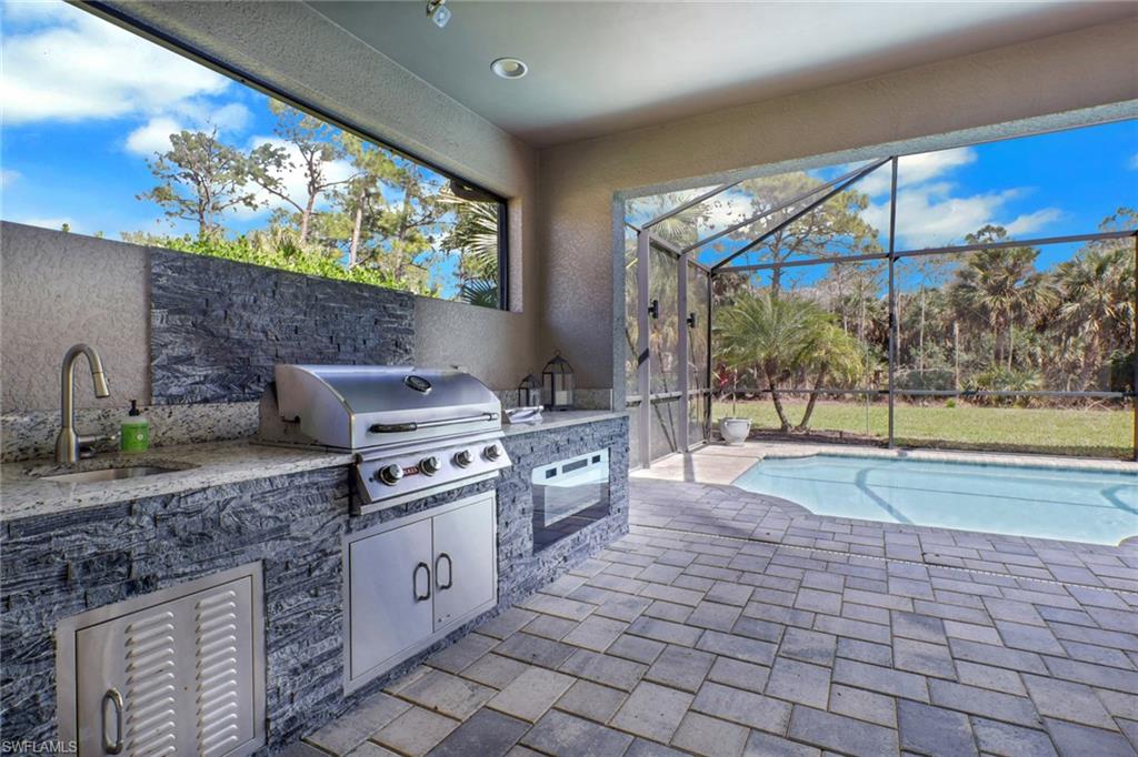 1511 Mockingbird Drive Naples, FL 34120 - Photo 34 of 44 a kitchen with stainless steel appliances granite countertop a stove a sink and a microwave