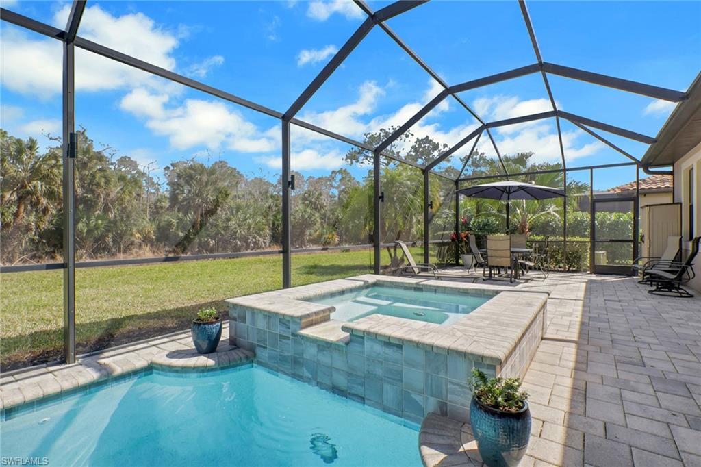1511 Mockingbird Drive Naples, FL 34120 - Photo 36 of 44 a view of a patio with a table and chairs under an umbrella
