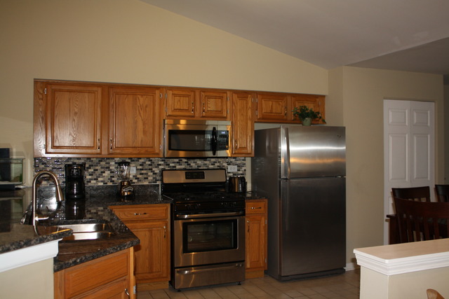 8251 Ripple Ridge Darien, IL 60561 - Photo 3 of 24 a kitchen with stainless steel appliances granite countertop a refrigerator stove and sink