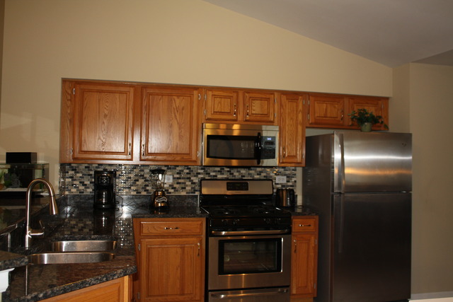 8251 Ripple Ridge Darien, IL 60561 - Photo 4 of 24 a kitchen with stainless steel appliances granite countertop a stove a sink and a refrigerator