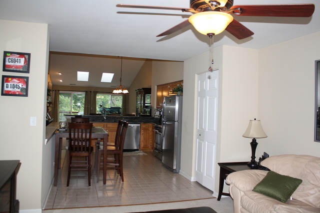 8251 Ripple Ridge Darien, IL 60561 - Photo 9 of 24 a kitchen with a dining table chairs and a refrigerator