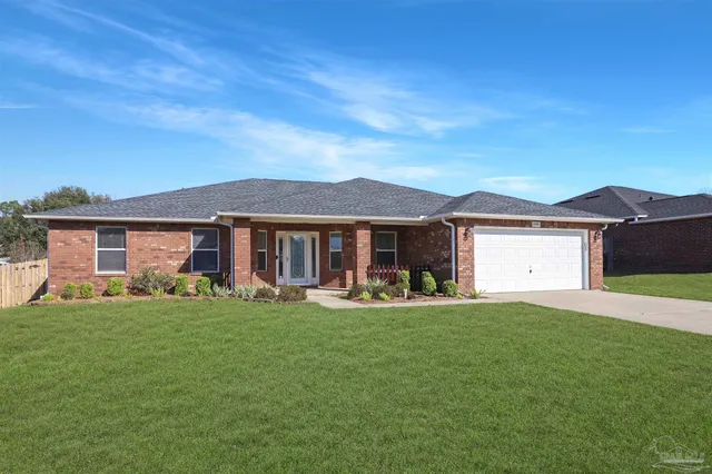 a front view of a house with a garden and trees