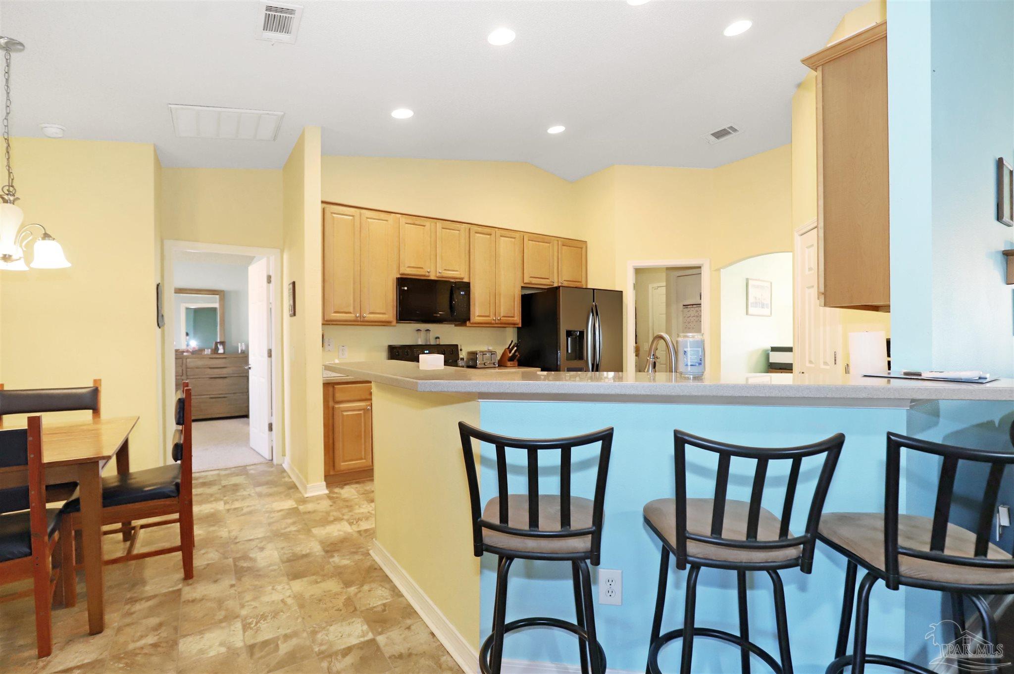 6006 Patch Lane Pensacola, FL 32526 - Photo 11 of 32 a kitchen with a table chairs refrigerator and cabinets