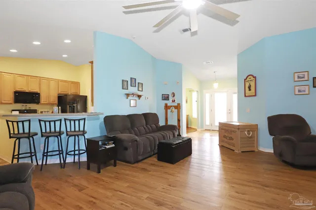 a living room with furniture and a wooden floor