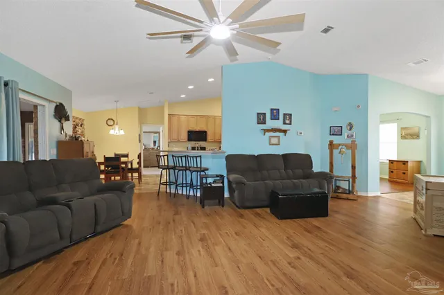 a living room with furniture and a wooden floor