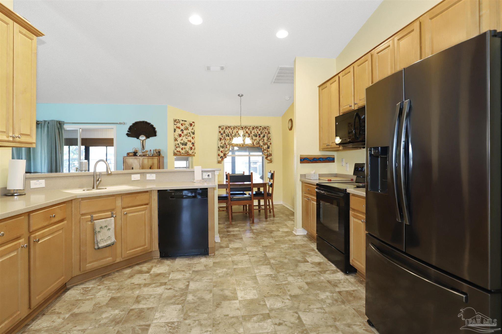 6006 Patch Lane Pensacola, FL 32526 - Photo 9 of 32 a kitchen with stainless steel appliances granite countertop a refrigerator a stove a sink a dining table and chairs