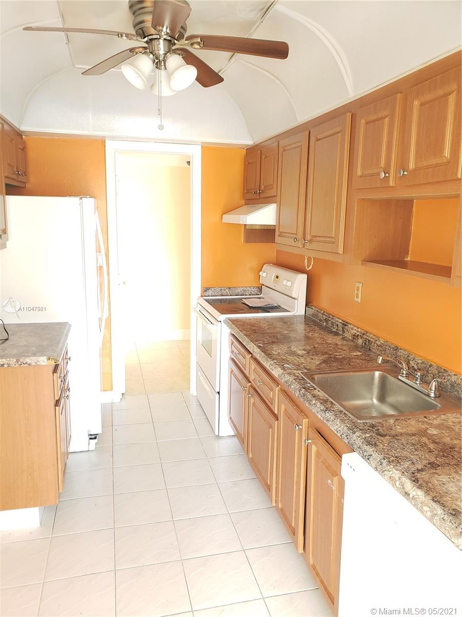 4174 Inverrary Drive, Unit 702 Lauderhill, FL 33319 - Photo 6 of 17 a kitchen with stainless steel appliances granite countertop a sink and a stove