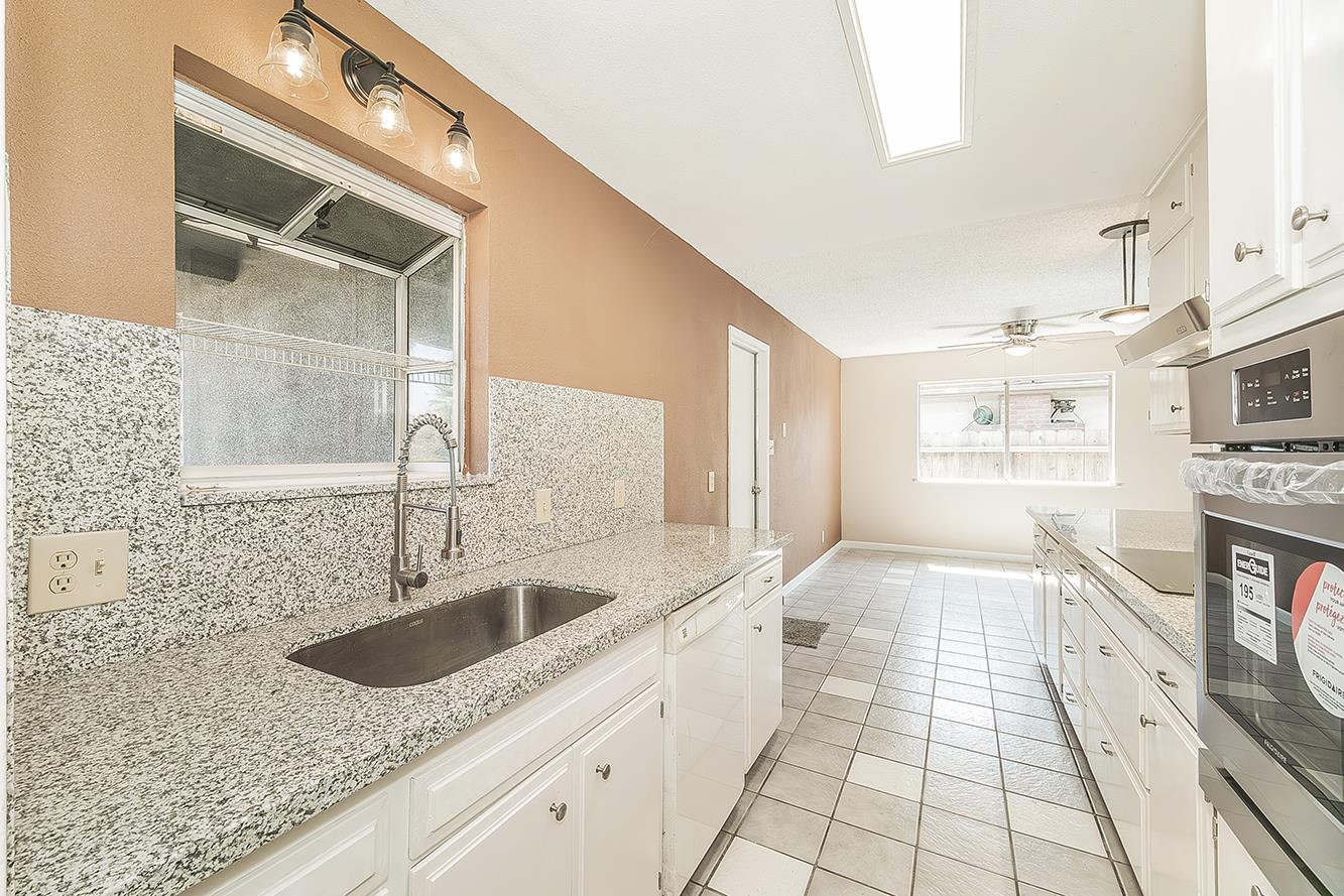 1375 South Cyrier Avenue Reedley, CA 93654 - Photo 12 of 34 a kitchen with stainless steel appliances granite countertop a sink and a stove