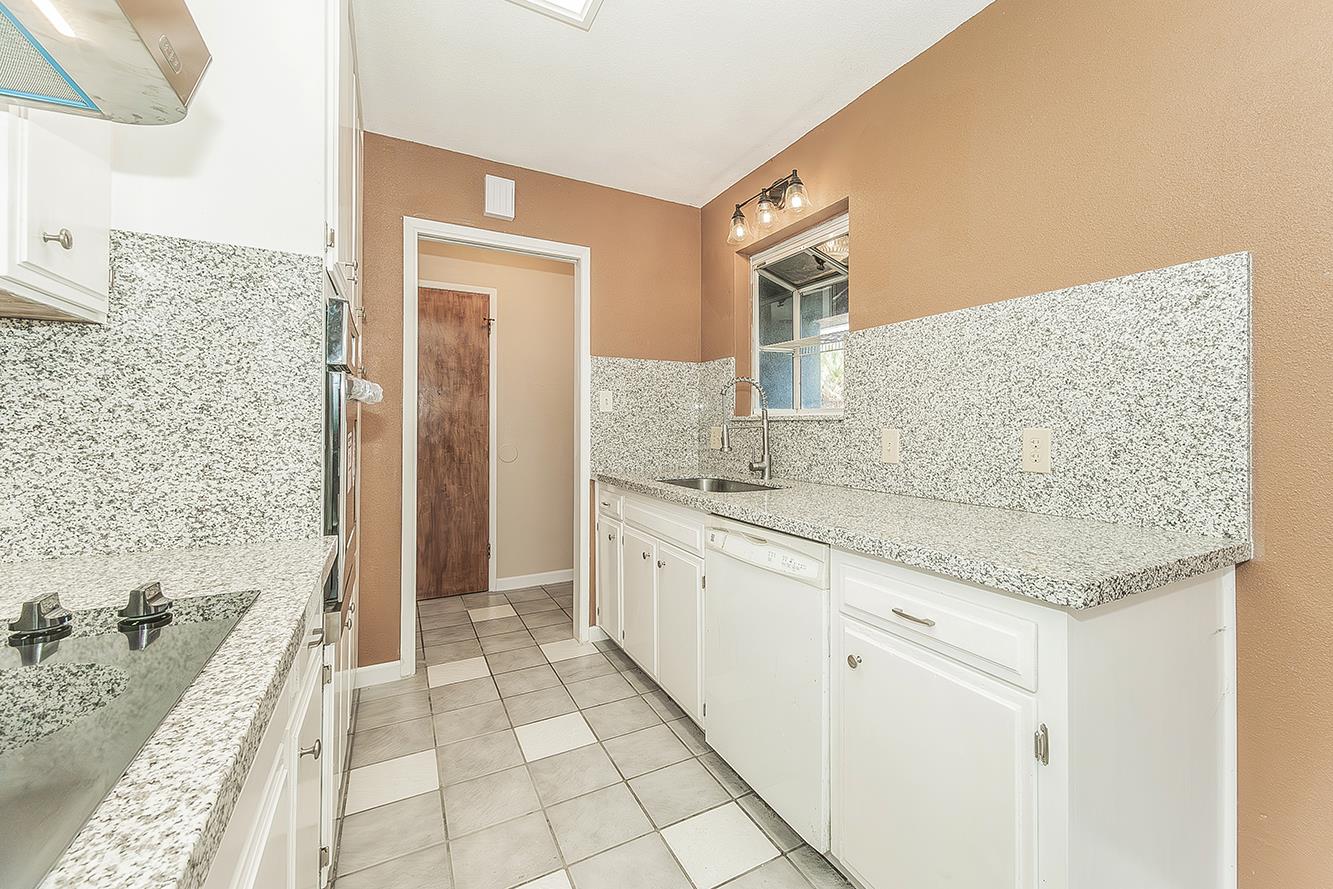 1375 South Cyrier Avenue Reedley, CA 93654 - Photo 9 of 34 a spacious bathroom with a granite countertop sink a mirror and a bathtub