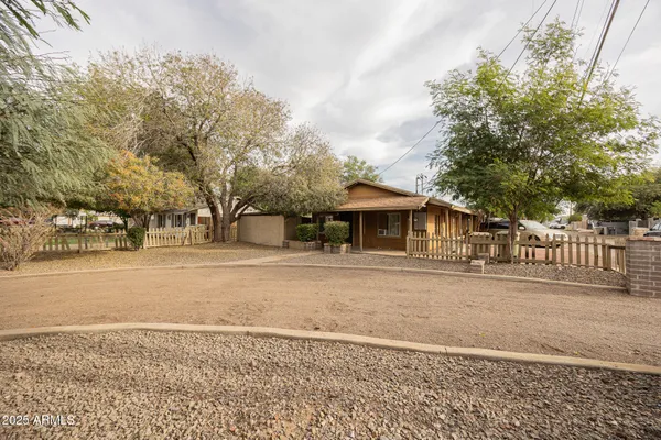 a front view of a house with a yard and trees