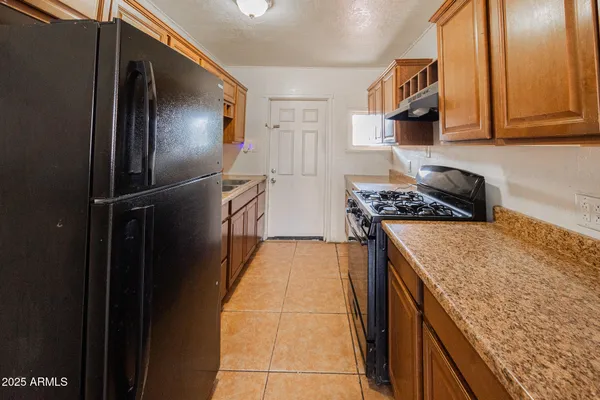 a kitchen with stainless steel appliances granite countertop a refrigerator and a stove top oven
