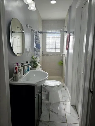 a bathroom with a sink a toilet and a mirror