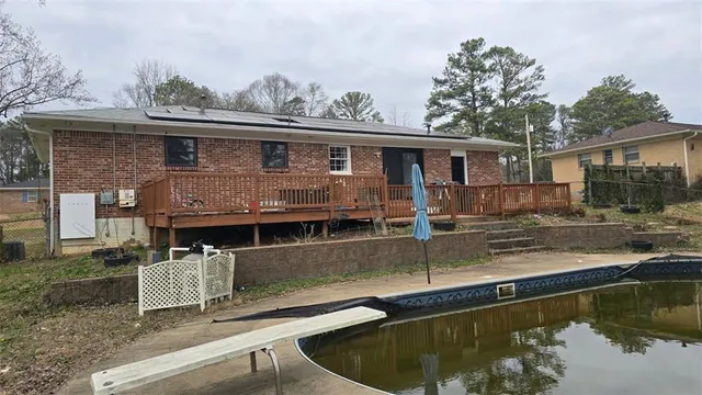 a view of a house with pool yard and a wooden deck