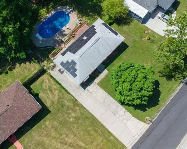 a view of a house with a yard and potted plants