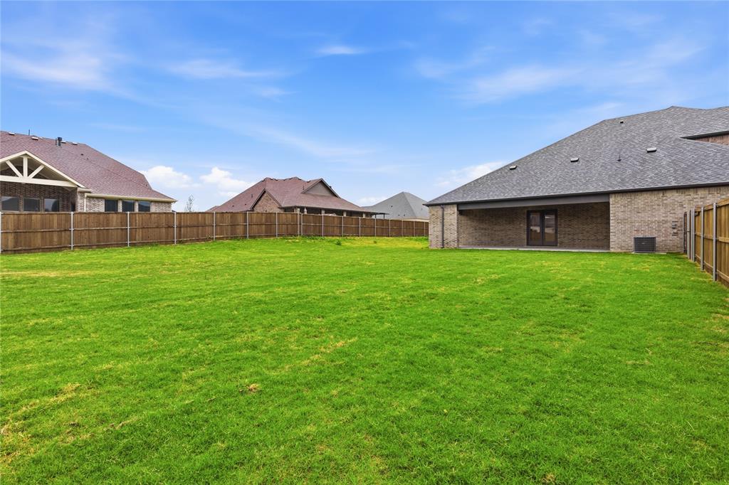 702 Anne Road Van Alstyne, TX 75495 - Photo 25 of 27 Expansive green lawn with a wood privacy fence