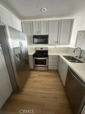 a kitchen with granite countertop a refrigerator and a sink