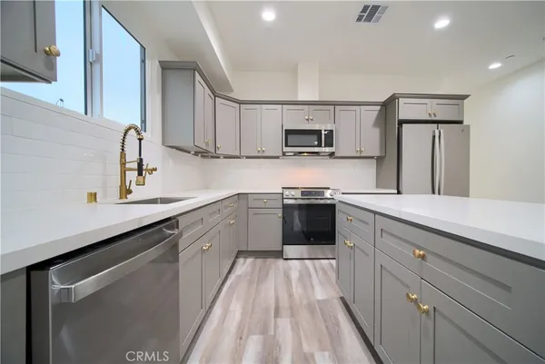 a kitchen with kitchen island white cabinets and sink