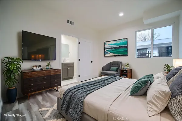 a bedroom with a bed and a flat screen tv