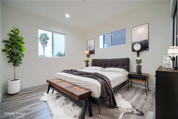a bedroom with a bed table and a potted plant