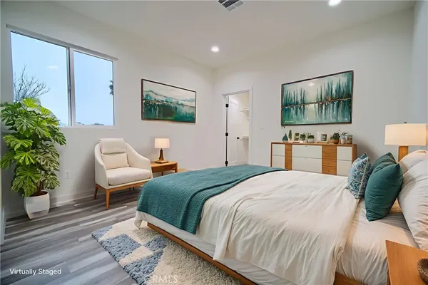a bedroom with a bed and a potted plant