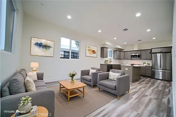 a living room with furniture kitchen view and a refrigerator