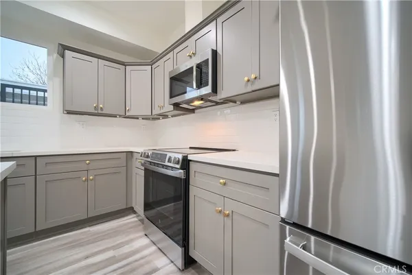 a kitchen with stainless steel appliances granite countertop white cabinets and a stove top oven