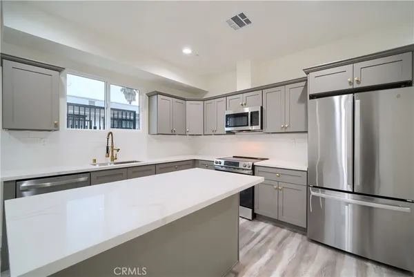 a kitchen with a sink appliances and cabinets