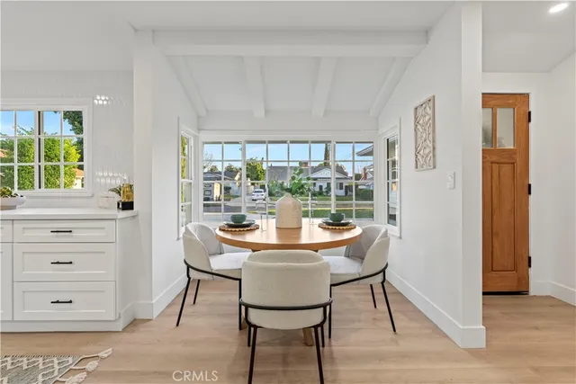 a dining room with furniture a rug and a floor to ceiling window