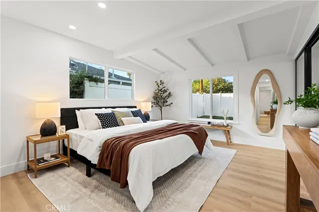 a spacious bedroom with a bed a couch and large window