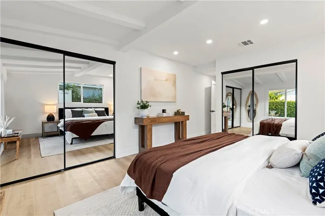 a bedroom with a large bed and a view of living room
