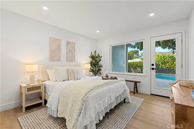 a bedroom with a large bed wooden floor and window