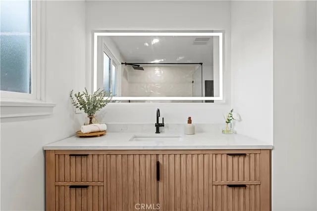 a bathroom with a sink a mirror and vanity