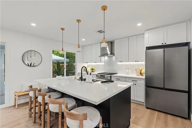 a kitchen with stainless steel appliances a table chairs and refrigerator